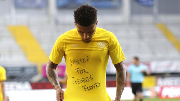 Jadon Sancho of Borussia Dortmund celebrates scoring his teams second goal of the game with a 'Justice for George Floyd' shirt during the German Bundesliga soccer match between SC Paderborn 07 and Borussia Dortmund at Benteler Arena in Paderborn, Germany, Sunday, May 31, 2020. Because of the coronavirus outbreak all soccer matches of the German Bundesliga take place without spectators. (Lars Baron/Pool via AP)