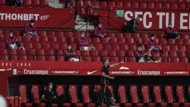 Sevilla's head coach Julen Lopetegui, center and bottom, gestures during the Spanish La Liga soccer match between Sevilla and Betis in Seville, Spain, Thursday, June 11, 2020. With virtual crowds, daily matches and lots of testing for the coronavirus, soccer is coming back to Spain. The Spanish league resumes this week more than three months after it was suspended because of the pandemic, becoming the second top league to restart in Europe. The Bundesliga was first. The Premier League and the Italian league should be next in the coming weeks. (AP Photo)