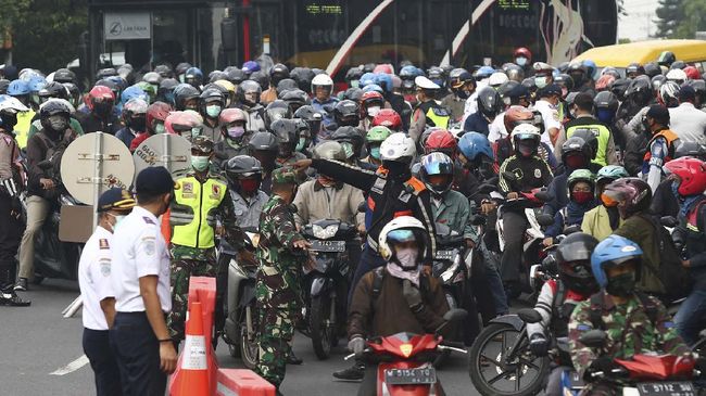 Petugas memeriksa dokumen kependudukan warga yang akan masuk ke Surabaya di Bundaran Waru, Surabaya, Jawa Timur, Selasa (28/4/2020). Petugas gabungan memperketat akses masuk ke Surabaya dengan melakukan screening atau pemeriksaan kepada warga di hari pertama pelaksanaan Pembatasan Sosial Berskala Besar (PSBB) di Surabaya. ANTARA FOTO/Didik  Suhartono/foc.