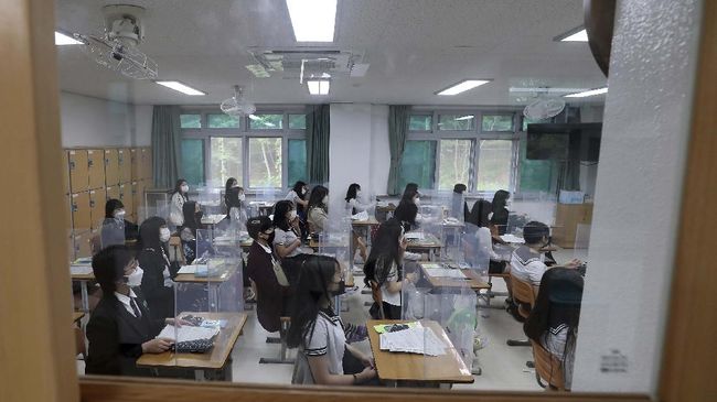 Senior students wait for a class to begin with plastic shields placed on their desks at Jeonmin High School in Daejeon, South Korea, Wednesday, May 20, 2020. South Korean students began returning to schools Wednesday as their country prepares for a new normal amid the coronavirus pandemic. (Kim Jun-beom/Yonhap via AP)