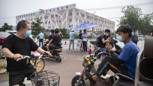 People wearing face masks to protect against the new coronavirus stop at a checkpoint outside the Xinfadi wholesale food market district in Beijing, Saturday, June 13, 2020. Beijing closed the city's largest wholesale food market Saturday after the discovery of seven cases of the new coronavirus in the previous two days. (AP Photo/Mark Schiefelbein)