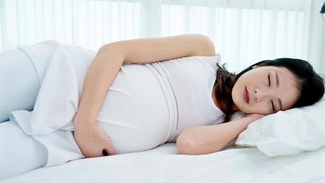 wanita muda sedang tidur dengan mimpi hamil