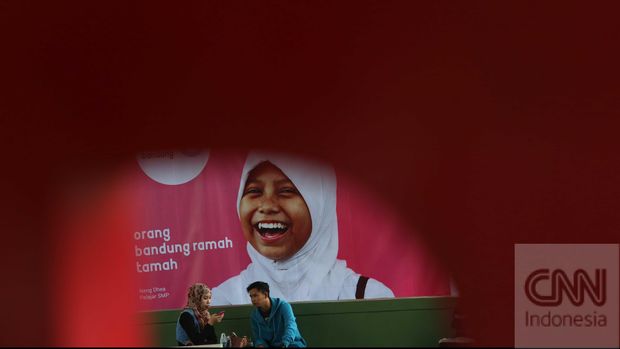 Polisi mengatur lalulintas dengan latar foto kampanye