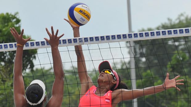 INDONESIA TUNDUKKAN THAILAND Atlet voli pantai Indonesia Putu Dini Jasita mengembalikan bola pada penyisihan voli pantai melawan pasangan Thailand Rumpaipruet Numwong dan Khanittha Hongpak di arena voli pantai Jakabaring Sport City, Senin (15/12). Indonesia memenangkan pertandingan tersebut dengan skor 21-19,21-17. ANTARA FOTO/ Feny Selly/ed/ama/14