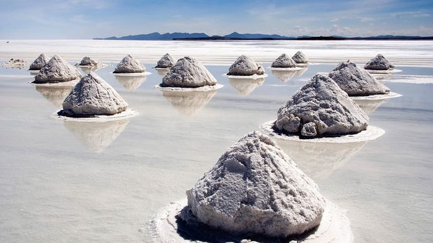 Salar de Uyuni, Bolivia Salt mounds in Salar de Uyuni, Bolivia. The Salar de Uyuni is the world's largest (12 000 km²) and highest (3 700 m) salt flat, ca. 25 times as large as the Bonneville Salt Flats. It's the remnant of a prehistoric lake surrounded by mountains without drainage outlets. Salt is harvested in the traditional method: the salt is scraped into small mounds for water evaporation and easier transportation, dried over fire, and finally enriched with iodine.