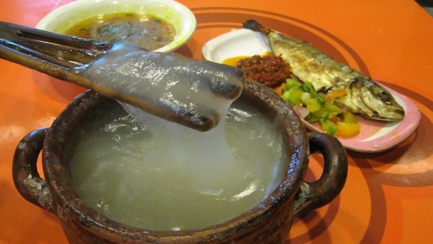 Papeda (sago congee), Kuah Kuning (yelow soup) and  Ikan Tude Bakar (grilled fish) with Dabu-dabu and Rica sambal. The Eastern Indonesian meal. Papeda, the staple food of Easter Indonesia have a glue-like consistency and texture. Waroeng Ikan Bakar, a restaruant specializing in Eastern Indonesian food (Manado, Maluku and Papuan cuisine). Atrium Senen Foodcourt, Jakarta, Indonesia.