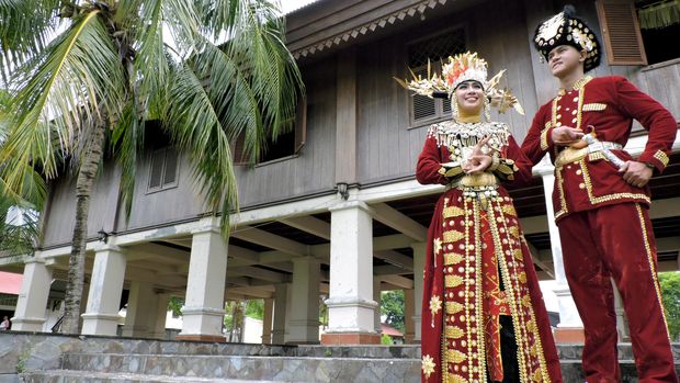 PAKAIAN ADAT GORONTALO Nou dan Uti (Putra dan Putri) Provinsi Gorontalo 2014 berpose mengenakan baju adat Gorontalo Bili'u (wanita) dan Makuta (pria) di rumah adat Dulohupa, Kota Gorontalo, Senin (8/6). Pakaian adat Gorontalo memiliki 4 warna adat, yaitu merah, kuning, ungu dan hijau yang biasa digunakan untuk pesta penikahan. ANTARA FOTO/Adiwinata Solihin/Rei/pras/15.