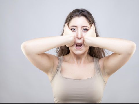 Beautiful young caucasian woman doing face yoga pose