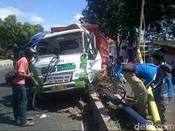 Dump Truk Muat Batu Nangkring di Median Jalan