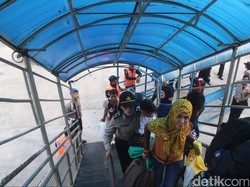 Polisi Ini Gendong Anak Pemudik Saat Menyeberang di Pelabuhan Tj Priok