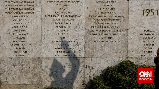 Bayangan seorang Veteran melihat nama-nama pejuang yang telah gugur, di Taman Makam Pahlawan Kalibata, Jakarta, 2015.