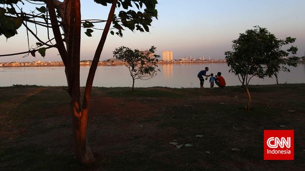 Seorang ibu memberi makan anaknya di Taman Kota Waduk Pluit, Jakarta Utara, Senin, 31 September 2015. Taman ini sudah menjadi tempat favorit sebagian warga Jakarta pada akhir pekan, pada saat matahari mulai meninggalkan siang, memasuki sore. CNN Indonesia/Safir Makki