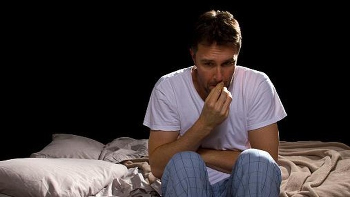 Frightened Woman in Bed with the Sheets Pulled Up to her Face