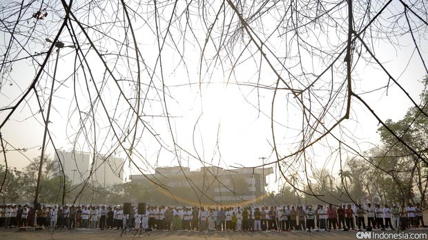 Warga Muhammadiyah membawa anaknya ketika melakukan salat Idul Adha di lapangan Pacuan Kuda Pulomas, Jakarta, 23 September 2015. Keluarga Besar Muhammadiyah menetapkan Hari Raya Idul Adha 2015 jatuh pada tanggal 23 September berdasarkan metode hisab. CNN Indonesia/Adhi Wicaksono.