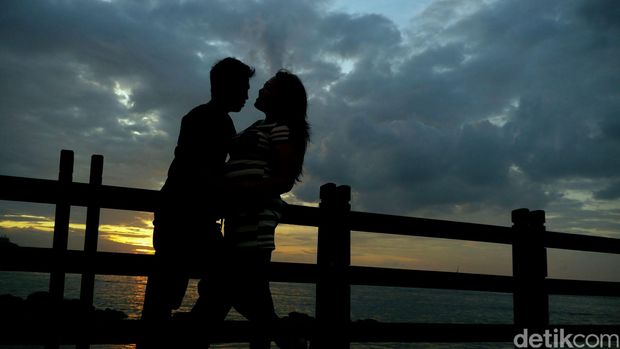 Sepasang kekasih menikmati suasana senja di pantai Ancol Jakarta. Detikfoto/Rengga Sancaya