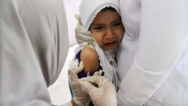 Petugas medis melakukan imunisasi campak kepada seorang siswa kelas I Sekolah Dasar (SD) saat pelaksanaan Bulan Imunisasi Anak Sekolah (BIAS) di SDN1 Lhokseumawe, Provinsi Aceh. Rabu (18/11). Kegiatan tersebut guna meningkatkan kesehatan siswa sekolah di seluruh Indonesia. ANTARA FOTO/Rahmad/15