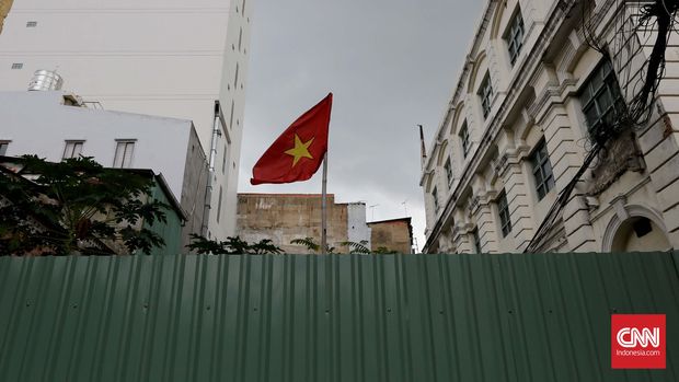 Bendera Vietnam berkibar di antara bangunan kuno dan baru di kawasan Nguyen Trung tuc kota Ho Chi Minh, Vietnam. CNN Indonesia/Safir Makki