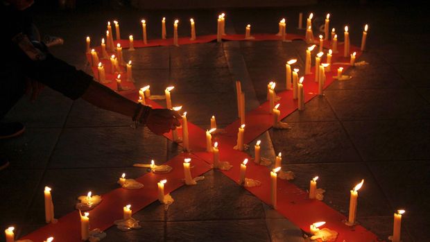 Mahasiswa Universitas Muhammadiyah (Unismuh) Makassar melakukan renungan dengan menyalakan lilin saat memperingati hari AIDS Sedunia di depan kampus Unismuh Makassar, Sulawesi Selatan, Selasa (1/12) malam. Aksi tersebut bertujuan memberikan pemahaman kepada masyarakat agar tidak melakukan diskriminasi terhadap penderita HIV AIDS. ANTARA FOTO/Abriawan Abhe/aww/15.