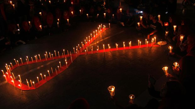 Mahasiswa Universitas Muhammadiyah (Unismuh) Makassar melakukan renungan dengan menyalakan lilin saat memperingati hari AIDS Sedunia di depan kampus Unismuh Makassar, Sulawesi Selatan, Selasa (1/12) malam. Aksi tersebut bertujuan memberikan pemahaman kepada masyarakat agar tidak melakukan diskriminasi terhadap penderita HIV AIDS. ANTARA FOTO/Abriawan Abhe/aww/15.