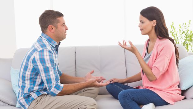 Couple arguing while sitting on sofa