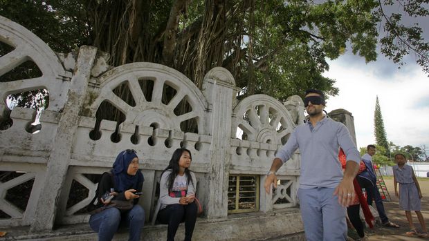 Wisatawan berusaha melintasi beringin kembar dengan mata tertutup di Alun-alun Kidul, DI Yogyakarta, Sabtu (2/1).  Melintasi beringin dengan mata tertutup atau sering disebut masangin menjadi daya terik tersendiri bagi wisatawan karena mitosnya hanya orang yang hatinya bersih saja yang dapat melakukan hal itu. ANTARA FOTO/Andreas Fitri  Atmoko/pd/15.