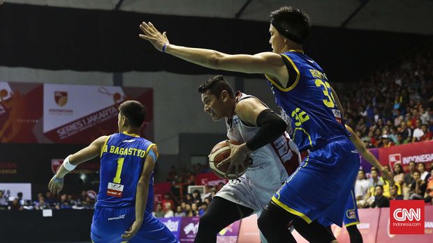 Pebasket Aspac Jakarta Rizky Lyandra (putih) berusaha melewati kawalan pebasket Satria Muda Jakarta Rony Gunawan (biru) pada laga IBL Musim 2016 di Hall A Senayan, Jakarta, Sabtu, 9 Januari 2016.  Satria Muda Pertamina berhasil menang 70-61. CNN Indonesia/Adhi Wicaksono