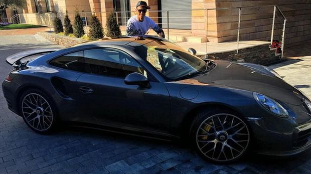 Cristiano Ronaldo memperlihatkan mainan terbarunya, sebuah mobil Porsche.