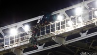 Sejumlah anggota TNI menolong penerjun yang tersangkut di atap stadion.