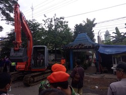Evakuasi Puing Pesawat, Ekskavator Robohkan Gapura Gang