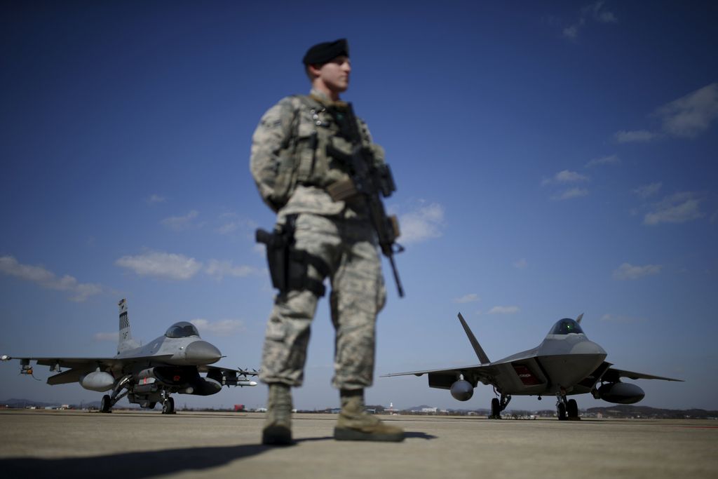 A U.S. army soldier stands guard in front of a F-22 stealth fighter jet (R) and F-15 fighter jet at Osan Air Base in Pyeongtaek, South Korea, February 17, 2016.  REUTERS/Kim Hong-Ji