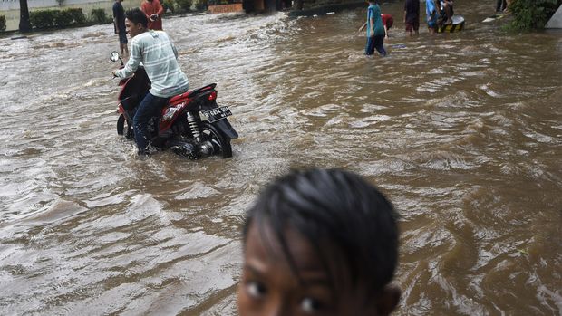 Pengendara motor melewati banjir yang melanda Jalan Gaya Motor, Sunter, Jakarta Utara, Kamis (25/2). Hujan yang mengguyur Jakarta sejak Rabu (24/2) malam membuat sejumlah kawasan tergenang banjir. ANTARA FOTO/Sigid Kurniawan/foc/16.