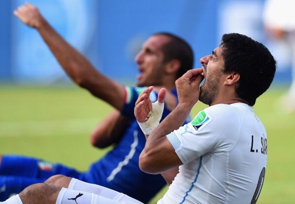   Luis Suarez of Uruguay and Giorgio Chiellini of Italy react after a clash during the 2014 FIFA World Cup Brazil Group D match between Italy and Uruguay at Estadio das Dunas on June 24, 2014 in Natal, Brazil.  (Photo by Matthias Hangst/Getty Images)