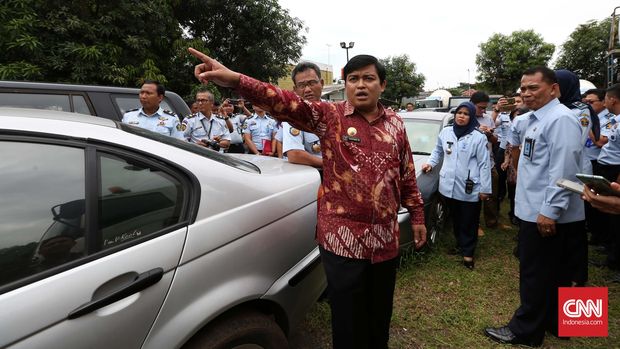 Dirjen Peraturan Perundang-undangan Kementerian Hukum dan HAM, Widodo Ekatjahjana (kiri) memeriksa mobil hasil sitaan KPK di gudang bersama Rumah Penyimpanan Benda Sitaan Negara (rupbasan) Jakarta Timur, Senin, 12 April 2016.