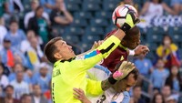 Fernando Muslera melompat untuk mengamankan gawangnya dari serangan para pemain Venezuela. Bill Streicher/Reuters/detikFoto.