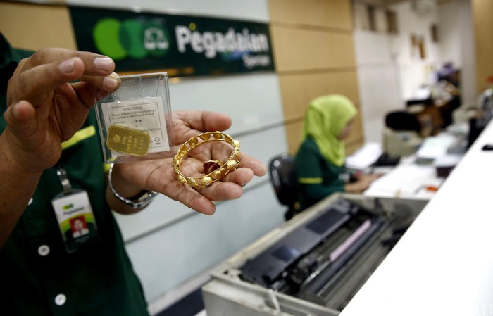 Seorang petugas menunjukan emas yang digadaikan oleh nasabah di kantor Pegadaian Pusat, Jakarta, Selasa (28/6/2016). Gadai emas menjadi pilihan warga untuk memenuhi kebutuhan jelang lebaran. Transaksi di Pegadaian pun meningkat dibanding bulan-bulan sebelumnya.