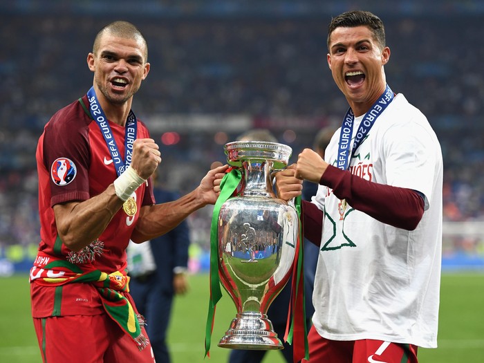 PARIS, FRANCE - JULY 10:  Cristiano Ronaldo (R) and Pepe (L) of Portugal pose for photographs holding the Henri Delaunay trophy to celebrate after their 1-0 win against France in the UEFA EURO 2016 Final match between Portugal and France at Stade de France on July 10, 2016 in Paris, France.  (Photo by Laurence Griffiths/Getty Images)