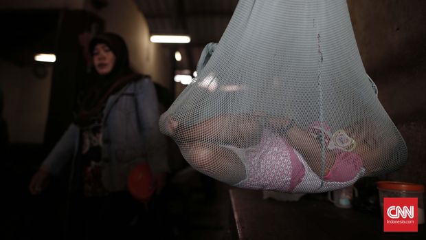 Seorang balita tidur di dalam ayunan di kawasan Pasar Sekanak Palembang, Sabtu, 16 Juli 2016. Yayasan Lembaga Konsumen Indonesia (YLKI) mengimbau pemerintah untuk segera memvaksinasi ulang balita yang positif mengonsumsi vaksin palsu. CNN Indonesia/Safir Makki