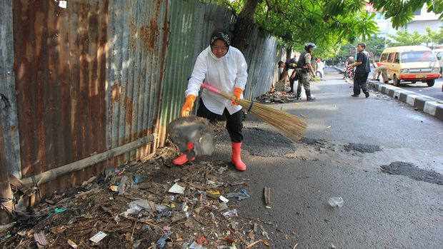 Wali Kota Surabaya Tri Rismaharini membersihkan jalan dari sampah di kawasan Jembatan Merah, Surabaya Jawa Timur, Senin (18/7). Kegiatan tersebut bertujuan agar kota Surabaya menjadi lebih bersih. ANTARA FOTO/Didik Suhartono/pd/16