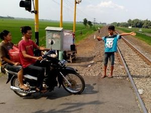 Mengintip Aktivitas Bocah Penjaga Perlintasan Tanpa Palang Pintu
