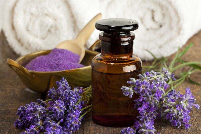 Lavender flowers, apothecary bottle, bowl of bath salt and towels
