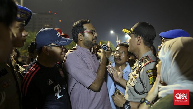 Koordinator Komisi untuk Orang Hilang dan Korban Tindak Kekerasan (Kontras), Haris Azhar, saat melakukan aksi diam di depan istana, Jakarta, Jumat, 19 Agustu 2016. Posko tersebut bertujuan memberikan akses kepada masyarakat untuk menyampaikan informasi mengenai keterlibatan aparat (Polri, TNI, BNN, dsb) dalam kejahatan narkotika. Sejak diresmikan pada 4 Agustus 2016 Posko tersebut telah menerima total 45 pengaduan dengan 38 kasus narkotika berkaitan dengan keterlibatan aparat dan 13 kasus berada di kawasan DKI Jakarta. CNN Indonesia/Adhi Wicaksono.