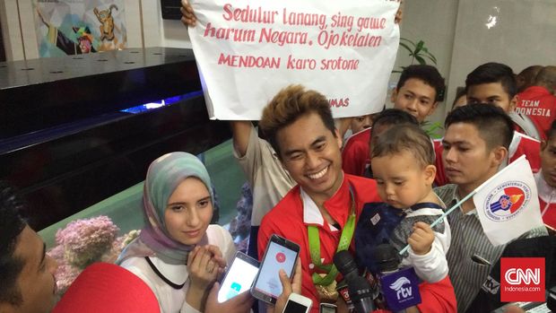 Tontowi Ahmad berpose bersama istrinya, Michelle Harmic, dan menggendong anaknya, Danish Arsenio Ahmad.