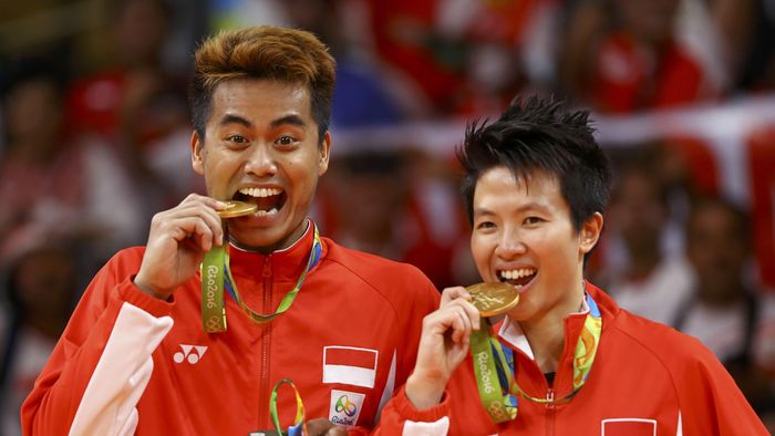 Tontowi-Liliyana 2016 Rio Olympics - Badminton - Mixed Doubles - Victory Ceremony - Riocentro - Pavilion 4 - Rio de Janeiro, Brazil - 17/08/2016. Gold medallists Tontowi Ahmad (INA) of Indonesia and Liliyana Natsir (INA) of Indonesia pose as if biting their medals. REUTERS/Mike Blake FOR EDITORIAL USE ONLY. NOT FOR SALE FOR MARKETING OR ADVERTISING CAMPAIGNS.