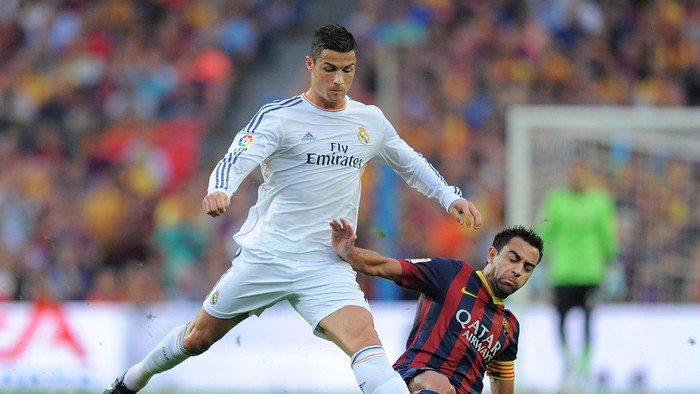 Ronaldo Xavi BARCELONA, SPAIN - OCTOBER 26:  Cristiano Ronaldo of Real Madrid CF (L) is tackled by Xavi Hernandez of FC Barcelona during the La Liga match between FC Barcelona and Real Madrid CF at Camp Nou stadium on October 26, 2013 in Barcelona, Spain.  (Photo by Denis Doyle/Getty Images)