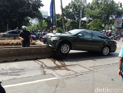 Bruuuk! Camry Hijau Ringsek Tabrak dan Nyangkut di Separator Busway