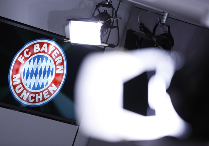 Bayern Logo MUNICH, GERMANY - MARCH 14: A club logo is seen behind TV lights during a press conference at the offices of German football club FC Bayern following the announcement by Uli Hoeness that he has resigned as club governing board chairman and will not appeal the three and half year jail sentence handed down by a Munich court the day before on March 14, 2014 in Munich, Germany. A judge found Hoeness guilty of evading taxes totaling at least EUR 27.2 million and declared his pre-emptive attempt at turning himself in to German tax authorities as invalid. Hoeness has been a pillar in German football club history, beginning with his career as a stellar professional player with FC Bayern in the 1970s to his role as FC Bayern club chairman, during which the Bundesliga team has been among the most successful in Germany. (Photo by Philipp Guelland/Getty Images)