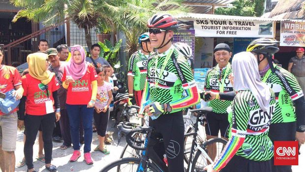 Gubernur Jawa Tengah Ganjar Pranowo tersenyum lebar saat melewati garis finis GFNY Indonesia di Lombok, Nusa Tenggara Barat, 2 Oktober 2016. (CNN Indonesia/Dika Dania Kardi)