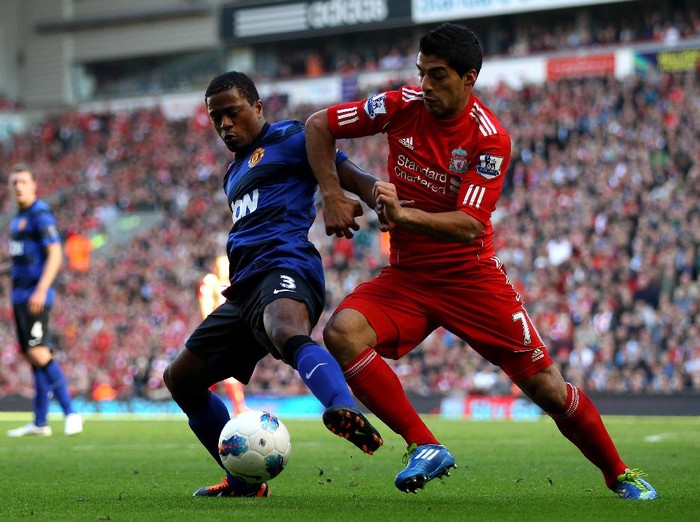 LIVERPOOL, ENGLAND - OCTOBER 15:  Luis Suarez of Liverpool tussles for posesssion with Patrice Evra of Manchester United during the Barclays Premier League match between Liverpool and Manchester United at Anfield on October 15, 2011 in Liverpool, England.  (Photo by Clive Brunskill/Getty Images)