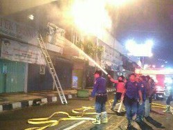 Sebuah Apotek di Jember Terbakar, Petugas Damkar Jebol Pintu untuk Padamkan Api