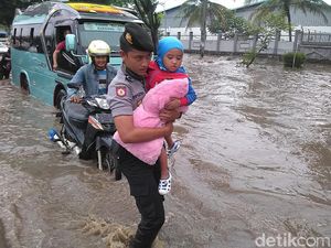 Ketika Polisi Gendong Anak-anak Terobos Genangan Banjir di Jalan Rancaekek
